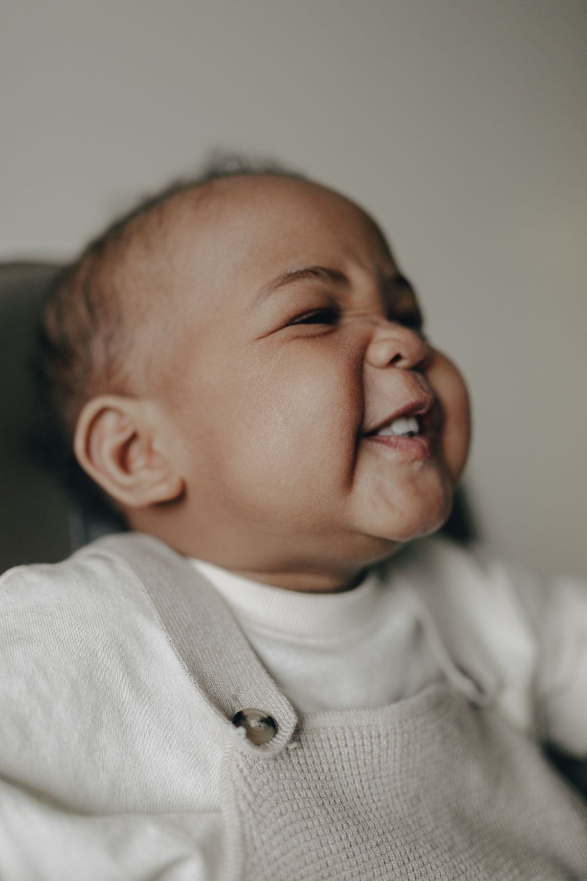 Blije baby glimlacht warm in een gezellig pakje