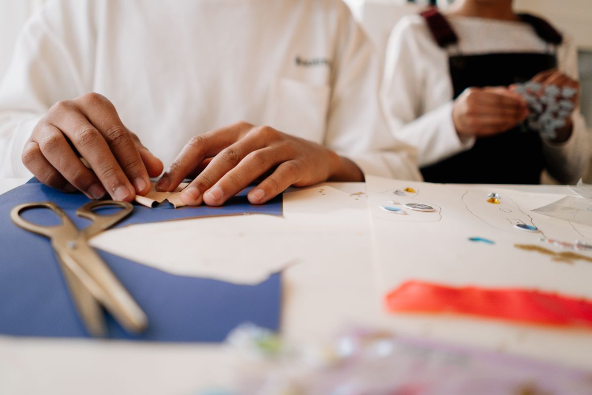 Kinderen knutselen aan tafel met papier en scharen