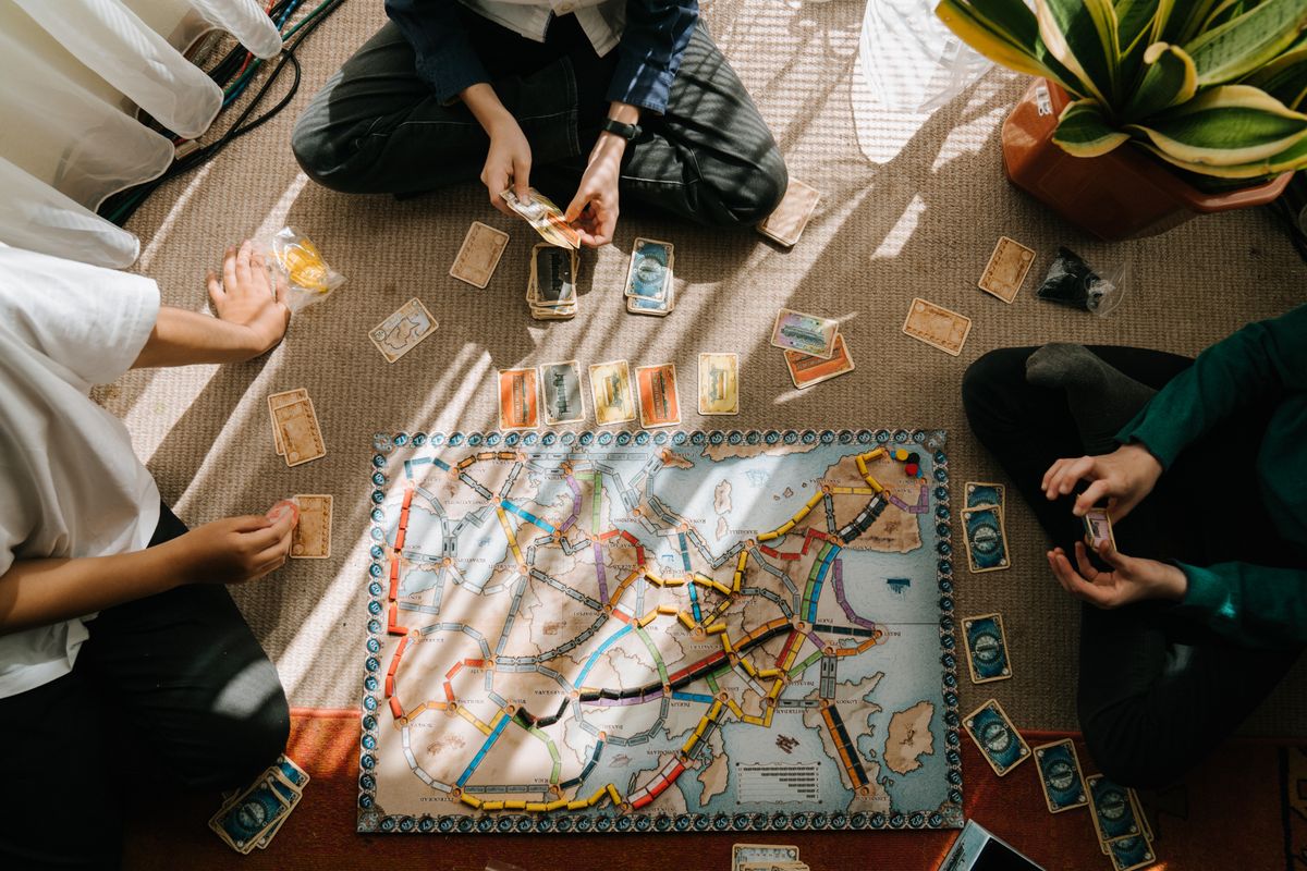 Groep kinderen speelt binnen een bordspel op het tapijt