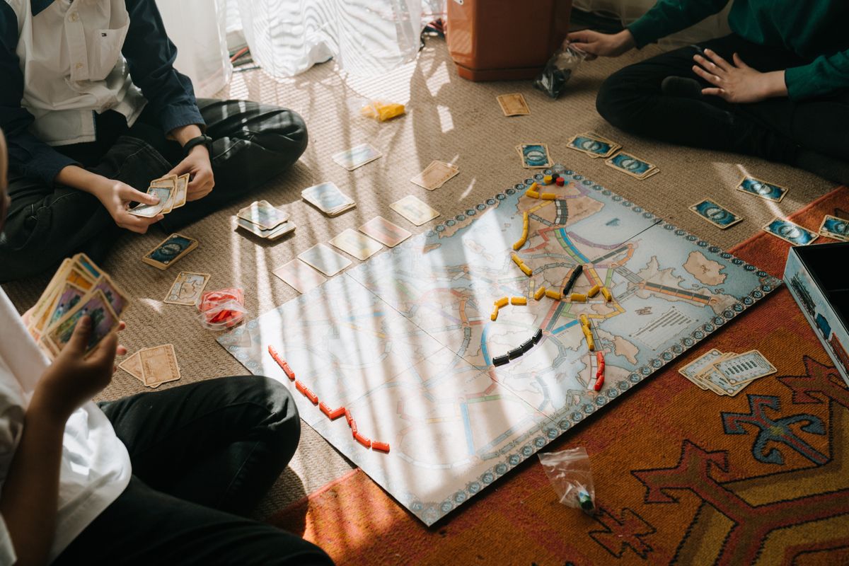 Kinderen spelen aan tafel een spel met kaarten en fiches