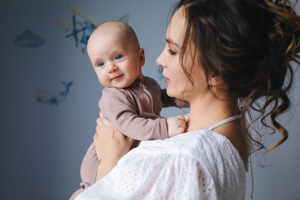 Moeder houdt haar baby vrolijk vast in een gezellige kamer