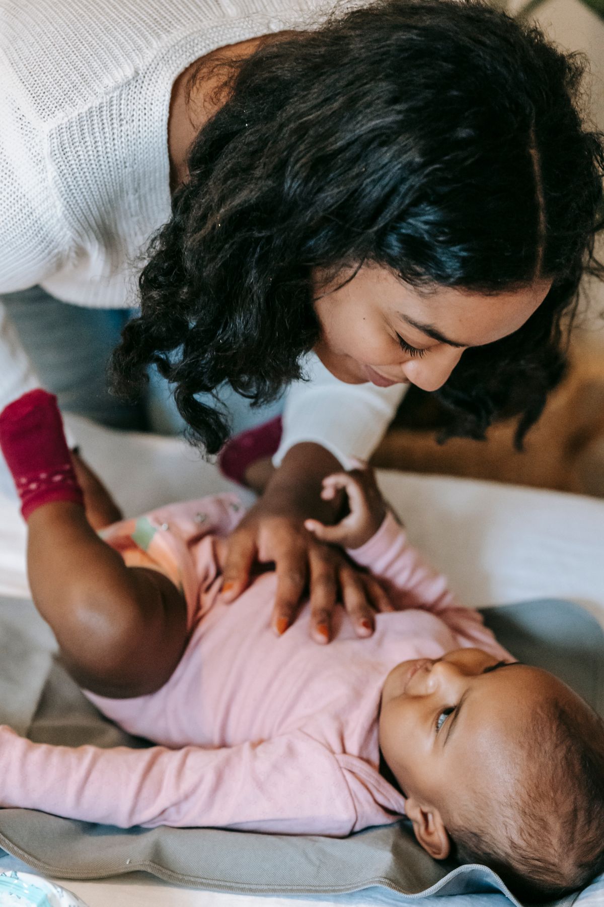 Moeder speelt met haar baby op de verschoontafel