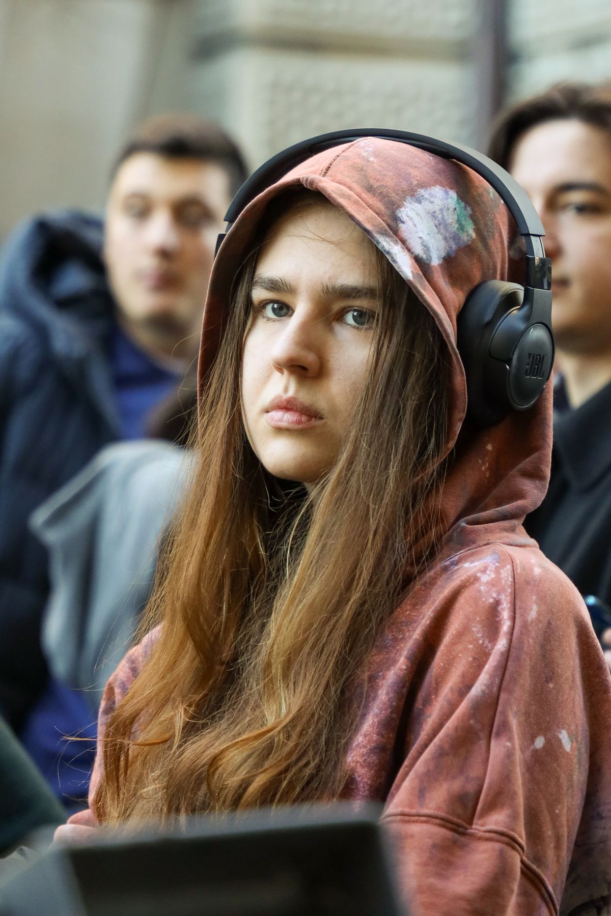 Groep tieners in hoodies luistert buiten naar muziek